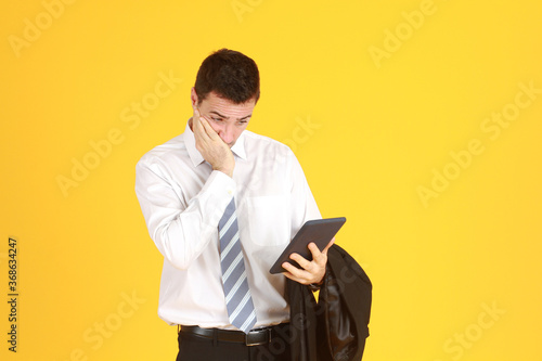 Handsome and smart businessman white shirt hand holding smartphone and Feeling stressed isolated on yellow background. Copy Space