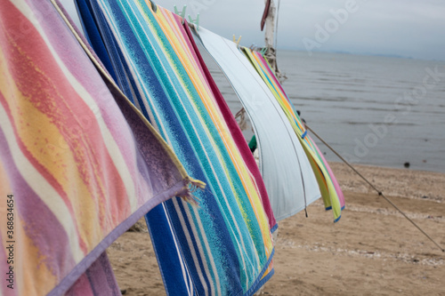 Beach towel blowing in the wind on a line. © bong
