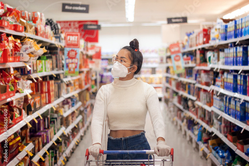 Young Asian women wearing face mask with canvas bag buying in supermarket.Panic shopping during Covid-19, Sydney Australia. photo