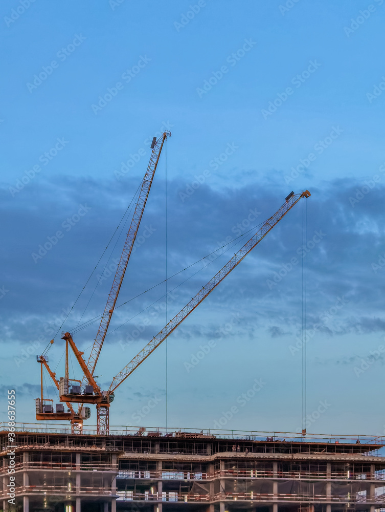 Construction site with cranes symbolize the construction boom in urban areas and urbanization with the population shift from rural to urban areas 
