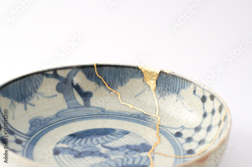 Antique Japanese ceramic kintsugi bowl restored with gold.  Antique kintsukuroi technique.