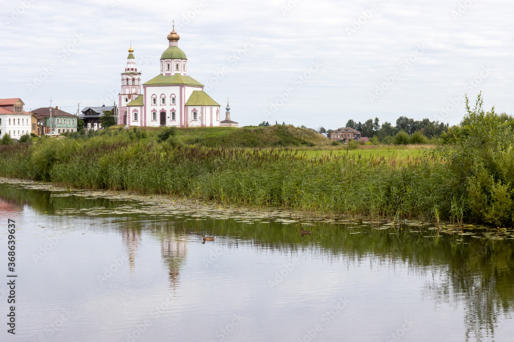 Beautiful pond and ducks with orthodox church on background in ancient town