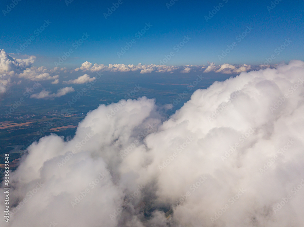 High flight in white curly clouds.