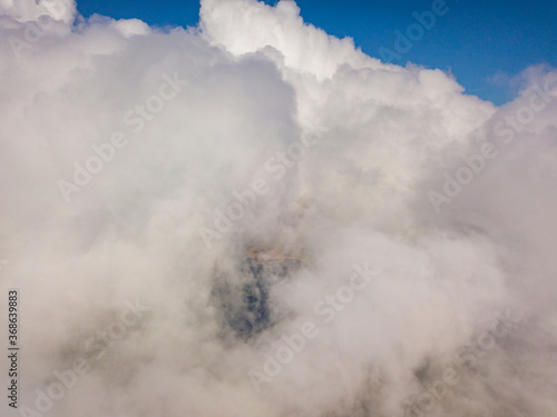 High flight in white curly clouds.