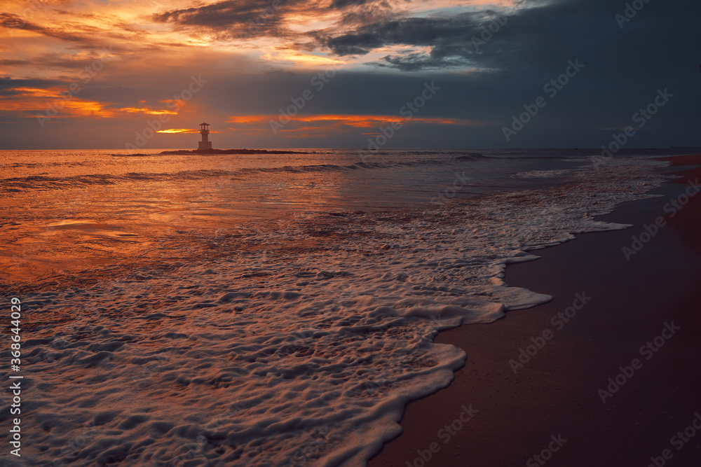 Seascape at sunset. Lighthouse on the coast