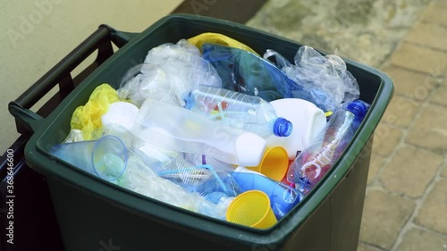 Waste bin full of plastic waste such as plastic bottles, cups, plastic bags and other plastic packaging ready for recycling