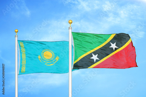 Kazakhstan and Saint Kitts and Nevis two flags on flagpoles and blue sky photo