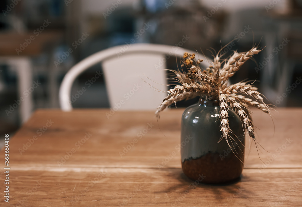Hygge home decor concept. Small ceramic vase with dried wheat spikes  standing on the table. Toned shot with copy space Stock Photo | Adobe Stock