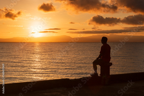 young man looking at the sunrise with hope © designbydx