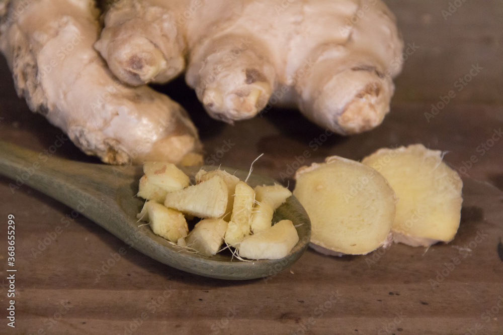 spoon with chopped ginger on rustic wood spoon with chopped ginger on rustic wood