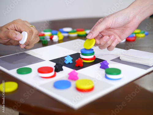 people playing fun board game on wooden table top selected focus