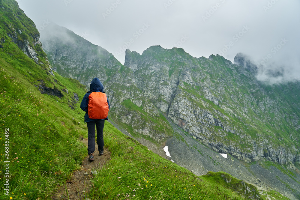 Fototapeta premium Lady hiker on a trail in the mountains