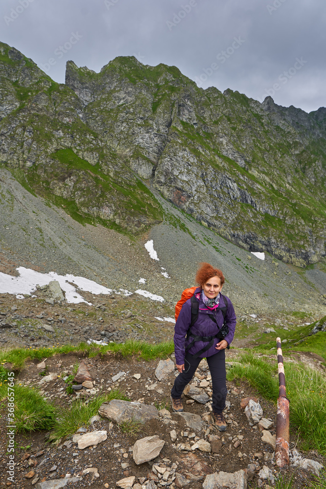 Lady hiker on a trail in the mountains