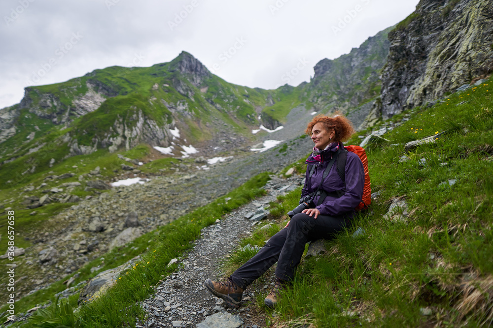 Naklejka premium Woman backpacker resting on the trail