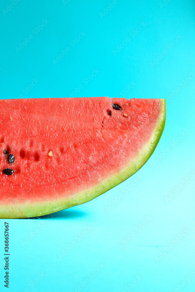 Fresh sliced watermelon isolated on blue background. Ripe red watermelon. Minimal creative concept. Place for text. Bright healthy summer food. Half watermelon Fresh sliced watermelon isolated on blue background. Ripe red watermelon. Minimal creative concept. Place for text. Bright healthy summer food. Half watermelon