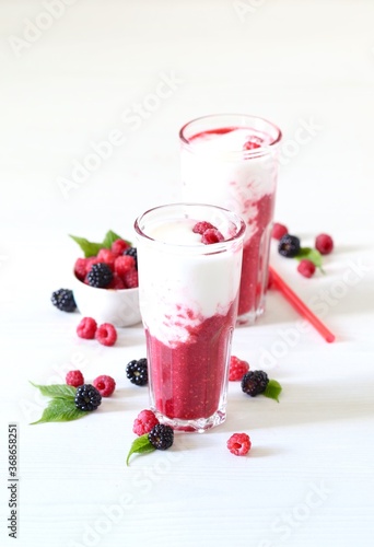 Milk berry refreshing drink, cocktail with ice cream, fresh raspberries and blackberries in a glass on a white background