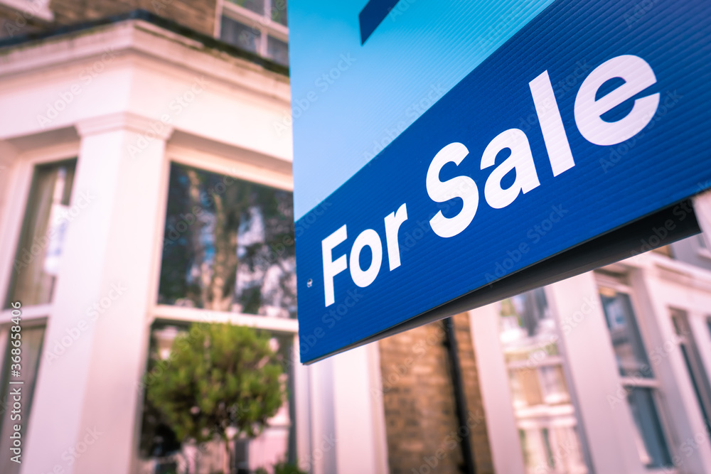 Obraz premium Estate agent 'For Sale' sign on street of houses