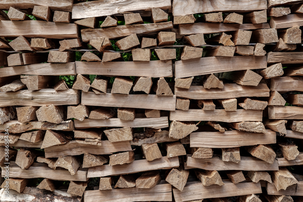 Firewood for the heating of the stove and fireplace, chopped into small pieces, are stacked perpendicular to each other. Firewood for the heating of the stove and fireplace, chopped into small pieces, are stacked perpendicular to each other.