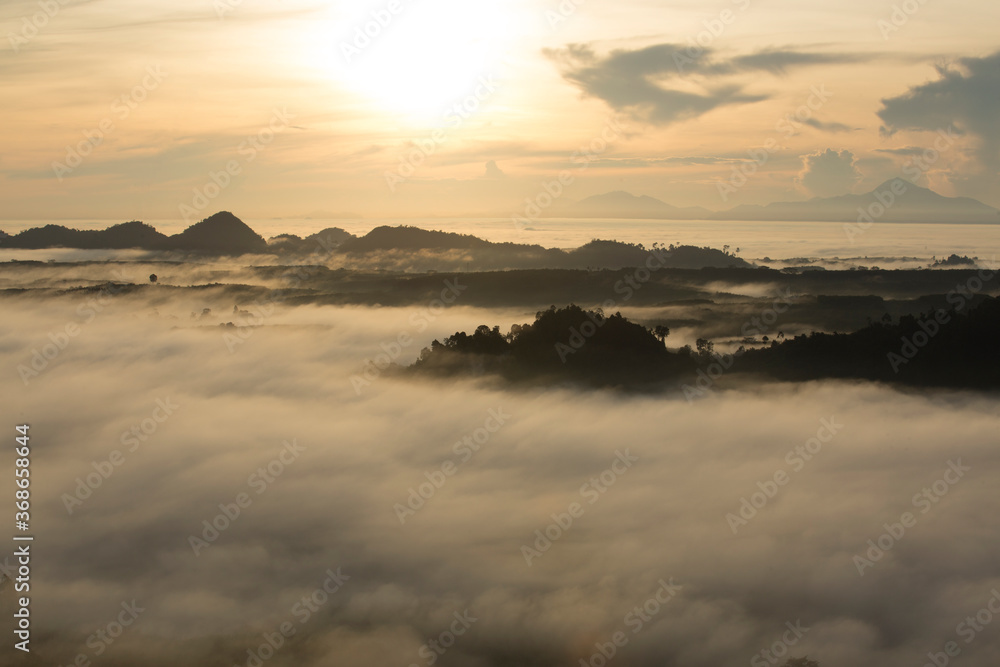 Amazing sunrise over misty landscape. Scenic view of foggy morning sky. Landscape sea of misty in dawn morning sunrise time at Khao Na Nai Luang Dhrama Park, Surat Thani province,Thailand Amazing sunrise over misty landscape. Scenic view of foggy morning sky. Landscape sea of misty in dawn morning sunrise time at Khao Na Nai Luang Dhrama Park, Surat Thani province,Thailand