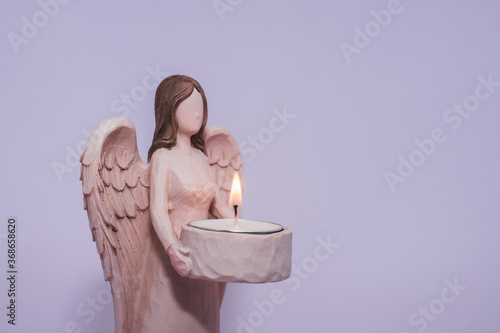 Anjo castiçal com vela acesa decorativo de natal segurando vela roxo escultura de resina photo