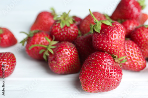 Delicious ripe strawberries on white wooden table, closeup