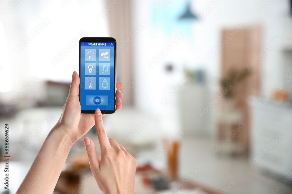 Woman using phone application for controlling smart home indoors, closeup