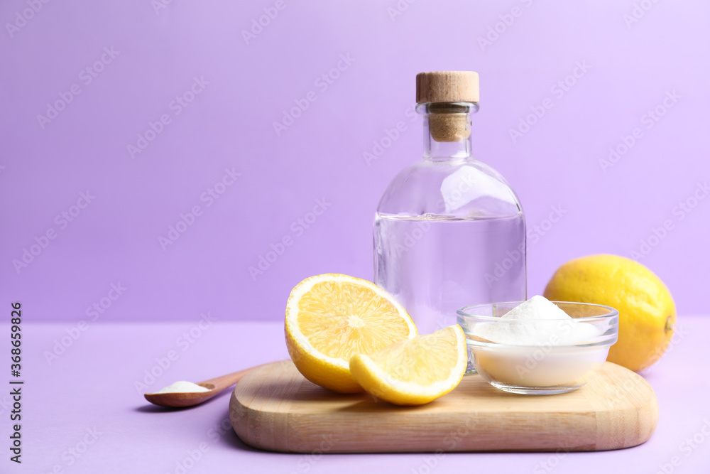 Baking soda, lemons and vinegar on lilac background. Space for text Baking soda, lemons and vinegar on lilac background. Space for text