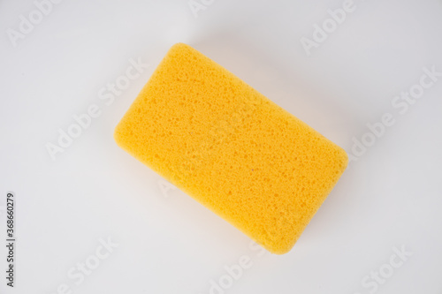 Sponge on white background. Yellow household cleaning sponge. photo