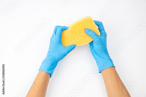 Sponge and spray for cleaning in female hand. Hand in a latex glove isolated on white. A hand in a glove holds a sponge and spray cleaning.