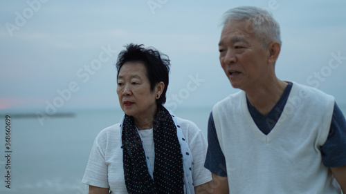 Asian senior elder couple holding hands looking sunset sea ocean together happy retirement life © glowonconcept