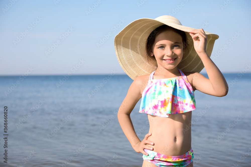 Cute little child with straw hat on sunny day. Beach holiday