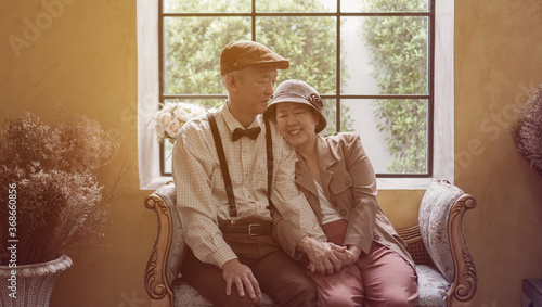 Vintage retro classic dress Asian elder senior couple taking photo at luxury home together