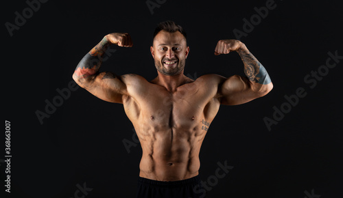Male bodybuilder on dark background, studio shot
