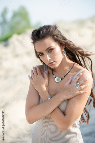 Outdoor high fashion portrait of young woman model posing with fashion accessories