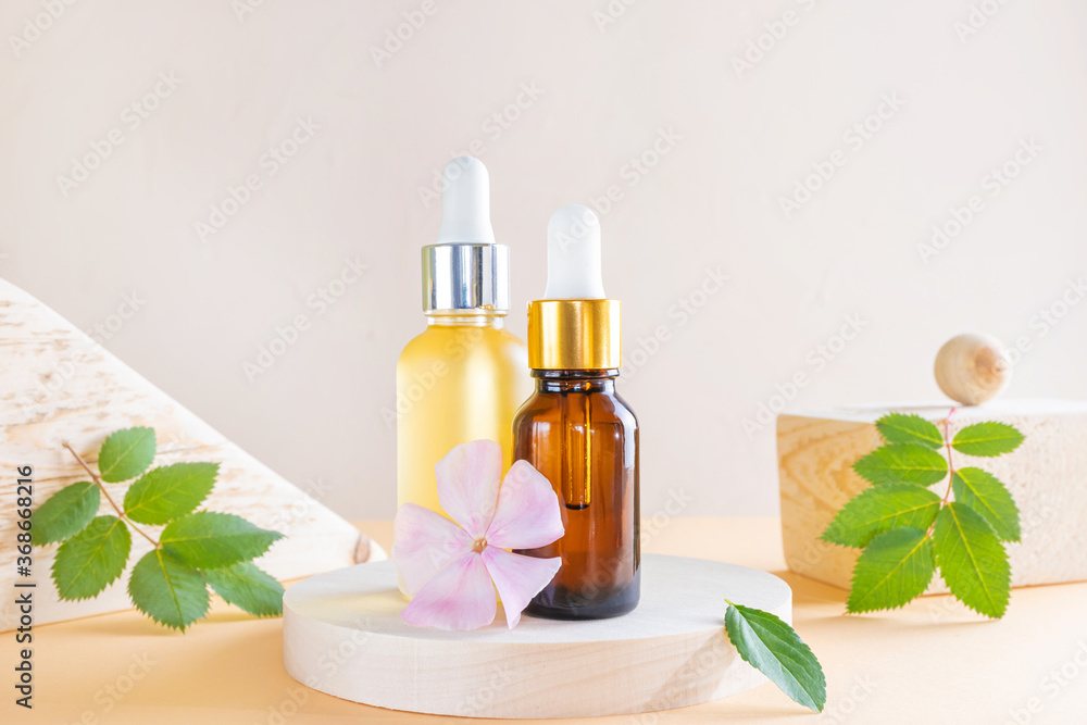 Cosmetic natural oil in a transparent bottles with a dispenser, wooden square and round. Wood, vegetation and oil. The concept of organic cosmetics, bio, eco, zero waste. Skin care, Aromatherapy. Cosmetic natural oil in a transparent bottles with a dispenser, wooden square and round. Wood, vegetation and oil. The concept of organic cosmetics, bio, eco, zero waste. Skin care, Aromatherapy.
