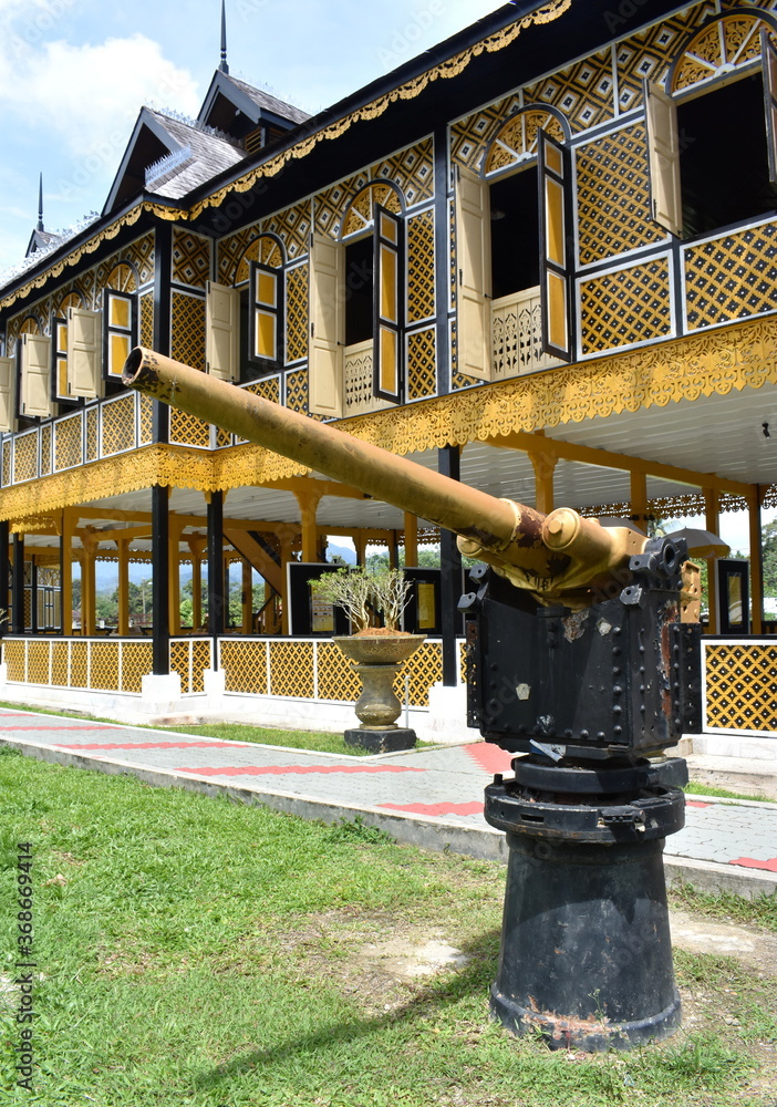 Old cannon outside a traditional wooden house in Kuala Kangsar, Malaysia