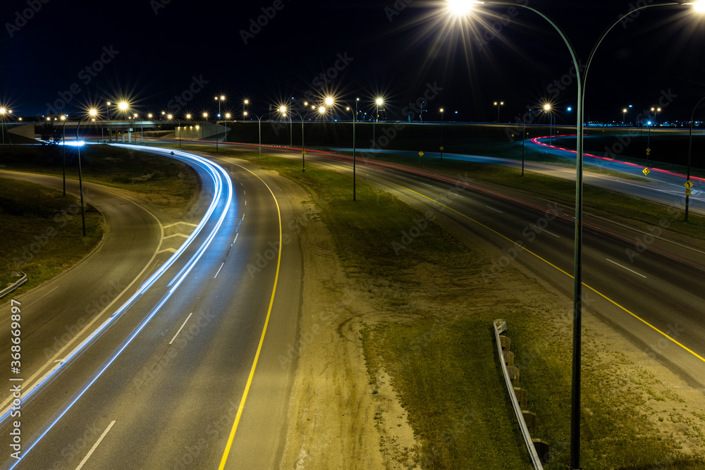 Light trails from vehicles travelling on the Circle Drive freeway late at night in Saskatoon, Saskatchewan Canada