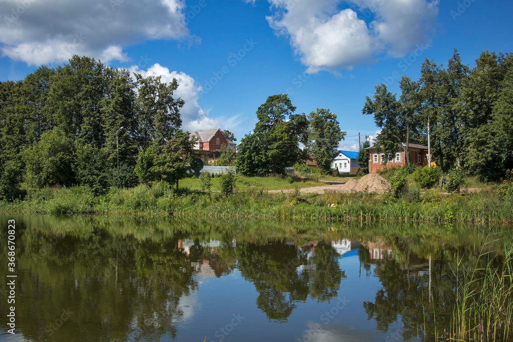 Residential house near pondin summer time. Residential house near pondin summer time.
