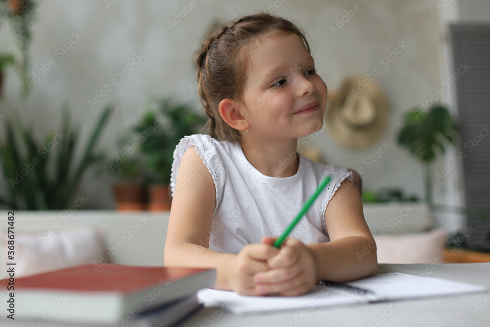 Little girl sit at desk, writing in notebook, do exercises at home, little child handwrite prepare homework. Little girl sit at desk, writing in notebook, do exercises at home, little child handwrite prepare homework.