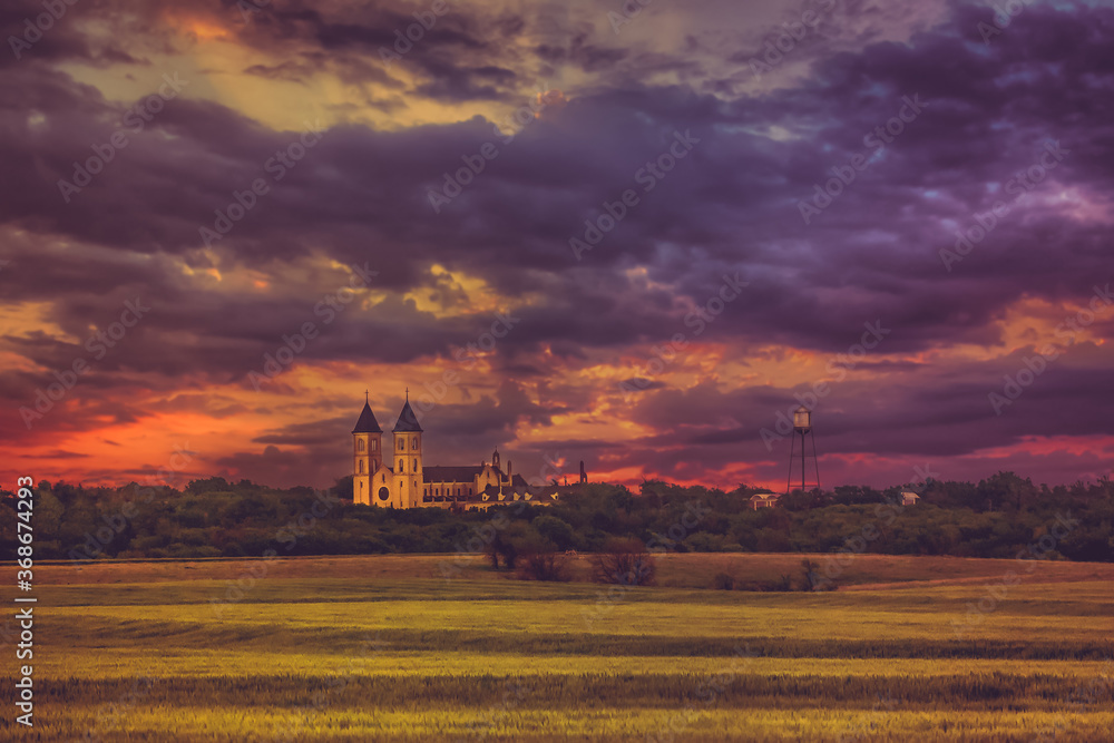 Fototapeta premium Victoria, KS USA - Panorama View of the Midwest Wheat Field Prairie and Cathedral of the Plains in Victoria Kansas USA Prairie in Sunset Sky Clouds