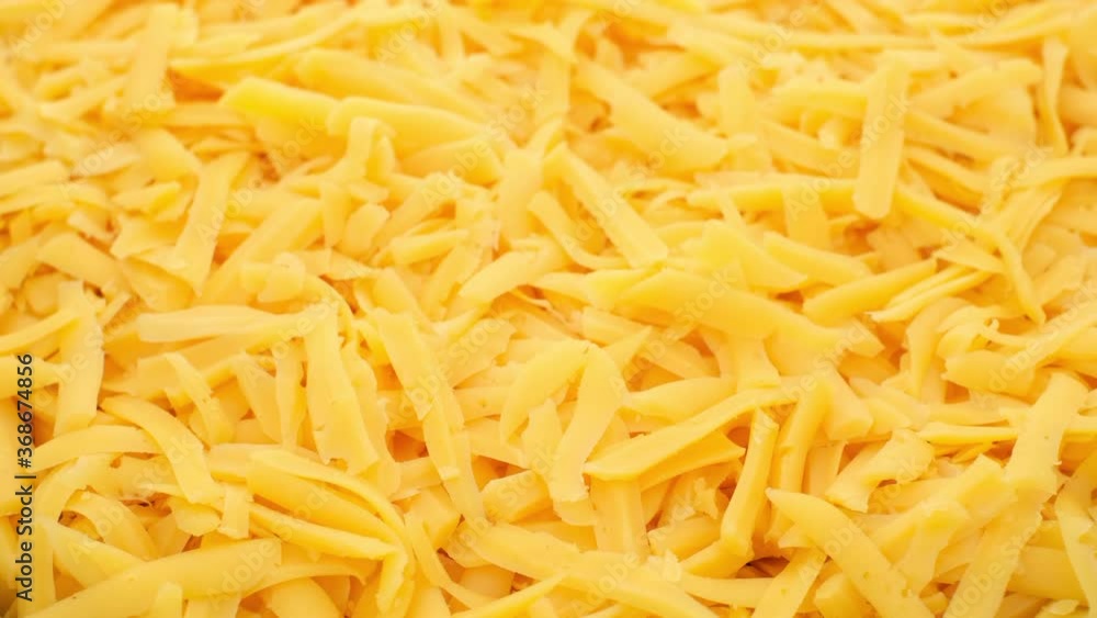 grated cheddar cheese rotating top view. grated cheese for pizza, pasta grated cheddar cheese rotating top view. grated cheese for pizza, pasta