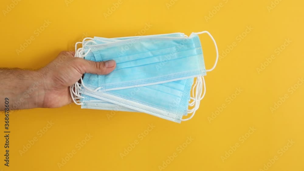 Medical masks to protect health from viruses such as coronavirus infection, video with yellow background Medical masks to protect health from viruses such as coronavirus infection, video with yellow background