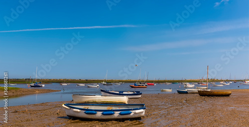 Boats on the shore and moored in Brancaster Bay near Burnham, Norfolk, UK photo