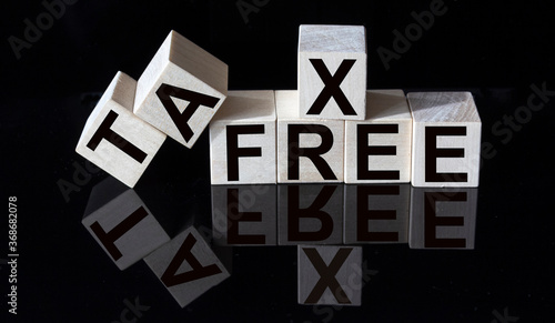 TAX FREE words on wooden cubes and glass black background with reflection. photo