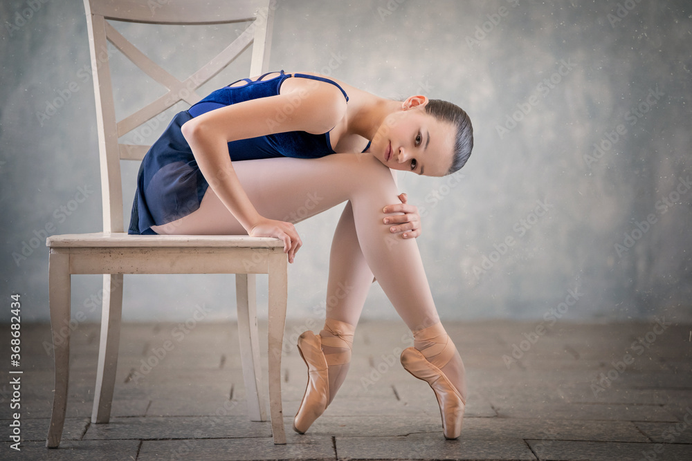 portrait of graceful ballet dancer in dark blue suit and pointe shoes. Dance, grace, artist, contemporary, movement, action.
