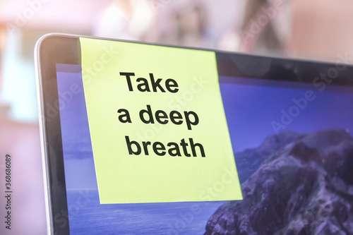 top view of words note on laptop computer screen with take a deep breath text