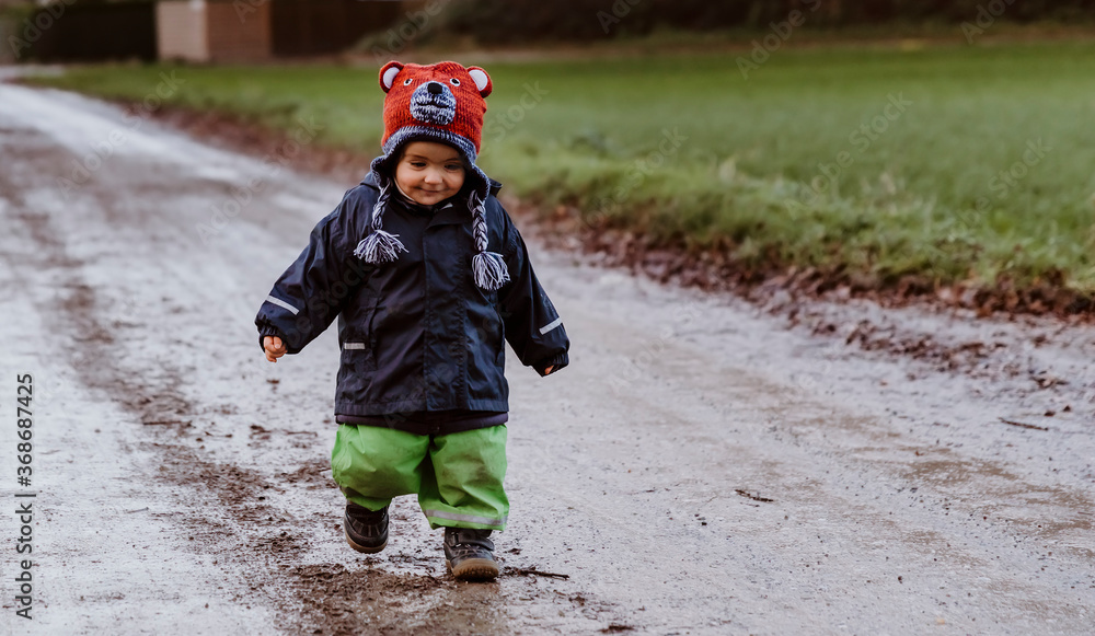 Toddler girl running on footpath between fields Toddler girl running on footpath between fields