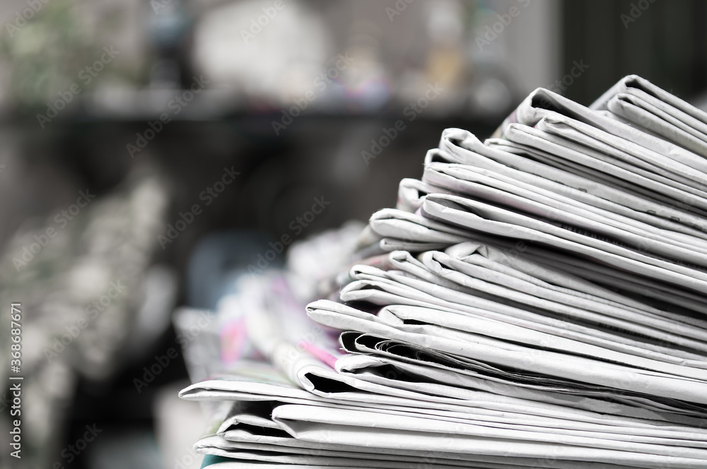Fotografie Newspapers folded and stacked on the table dark background