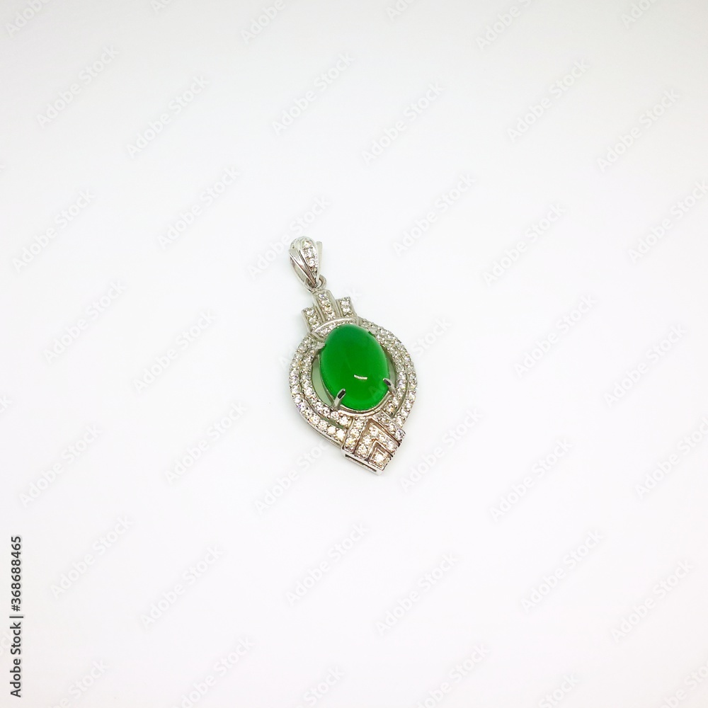 Diamond pendant with single emerald shot in studio Diamond pendant with single emerald shot in studio