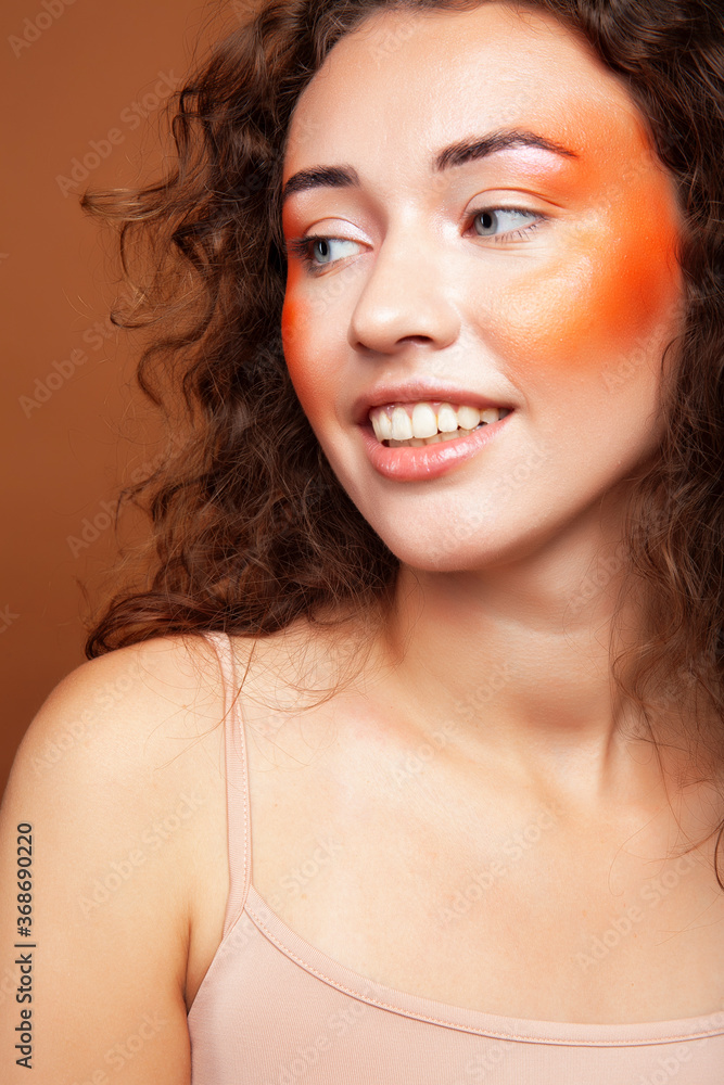 young pretty girl with curly hair posing cheerful on brown background, lifestyle people concept young pretty girl with curly hair posing cheerful on brown background, lifestyle people concept